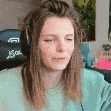 a woman wearing headphones and a sweater that says xcal