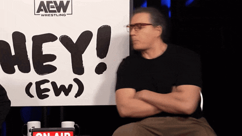 a man is sitting in front of a sign that says hey