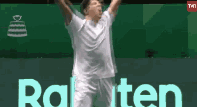 a man in a white shirt is jumping in the air with his arms in the air ..