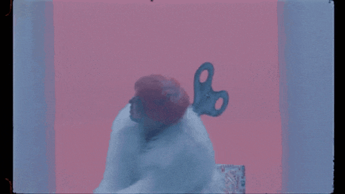 a person with a wind up key in their head against a pink and blue background