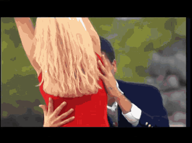 a woman in a red dress is being held by a man in a suit
