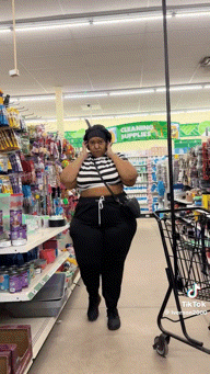 a woman wearing headphones walks through a grocery store