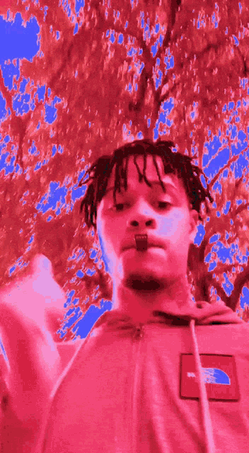 a man wearing a north face hoodie is giving a middle finger