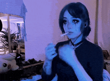 a girl with blue eyes is smoking a cigarette in a room