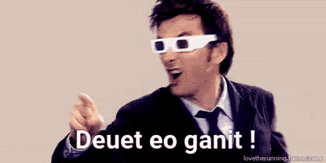 a man in a suit and tie is wearing 3d glasses and says deuet eo ganit !
