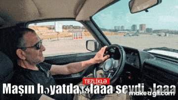 a man is driving a car with a make a gif.com logo on the bottom