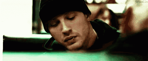 a close up of a man wearing a black beanie sitting at a pool table .