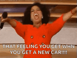 oprah winfrey is holding a microphone with her arms in the air and screaming .
