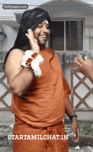 a man wearing a wig and an orange shirt with the words starttamilchat.in written on the bottom