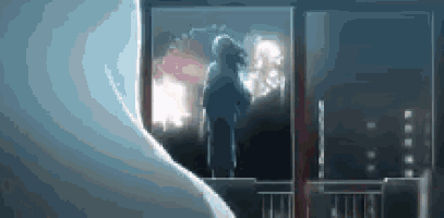 a person is standing in front of a window looking out at the city .