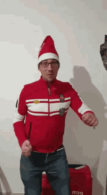a man wearing a santa hat and glasses is dancing in a room .
