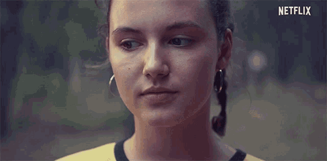 a close up of a woman 's face with the netflix logo in the corner