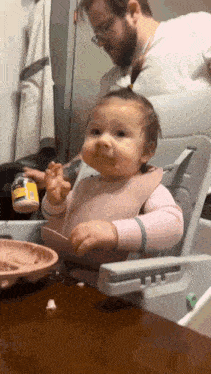 a baby is sitting in a high chair with a spoon in her mouth