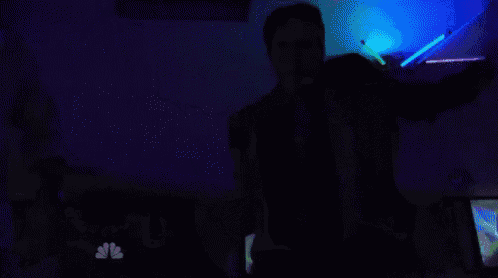 a man in a suit and tie is holding a gun in his hand .