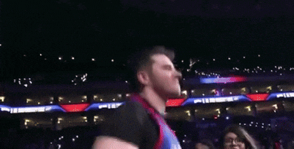 a group of people are clapping and applauding while a man in a blue jersey with the number 1 on it