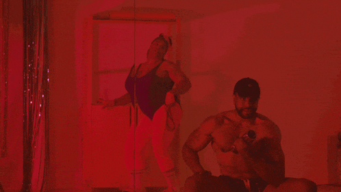 a woman in a bathing suit stands next to a man without a shirt