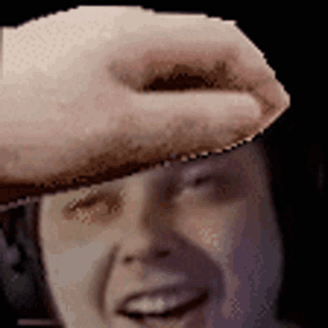 a close up of a person 's head with a hand on it