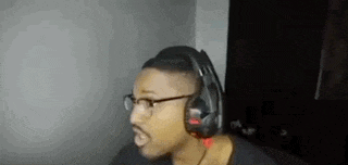 a man wearing headphones and glasses is talking into a microphone .