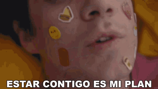 a person with stickers on their face and the words estar contigo es mi plan