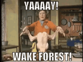 a woman is holding a dead chicken with the words yaaaay wake forest