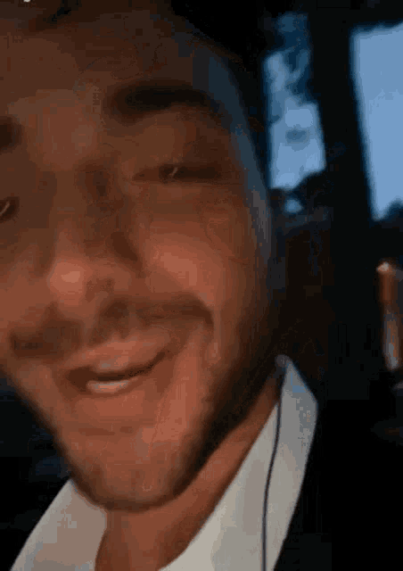 a close up of a man 's face with a beard and headphones smiling .