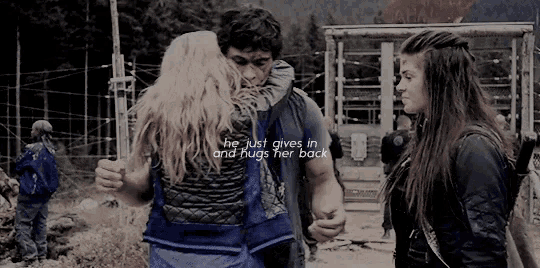 a man and a woman hugging with the words he just gives in and hugs her back on the bottom