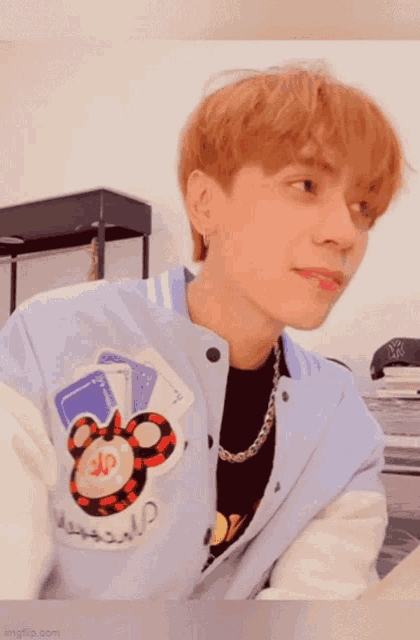 a close up of a person wearing a jacket with a mickey mouse embroidered on it