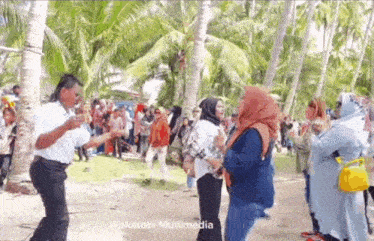 a man is dancing in front of a crowd of people with the words wakatobi multimedia at the bottom