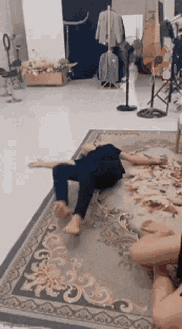 a person is laying on a rug in a living room