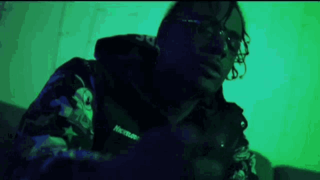 a man wearing glasses and a hoodie that says neverland