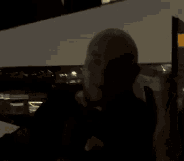 a bald man is standing in a dark room and says i 'm pretty nice ..