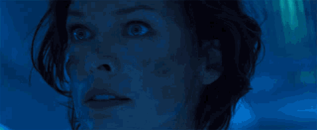 a close up of a woman 's face in a dark room