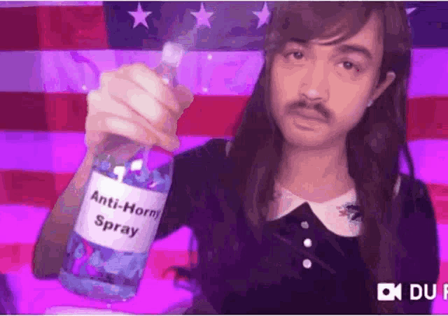 a man with a beard is holding a bottle of anti-horn spray .