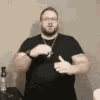 a man wearing a black shirt and glasses is giving a thumbs up .