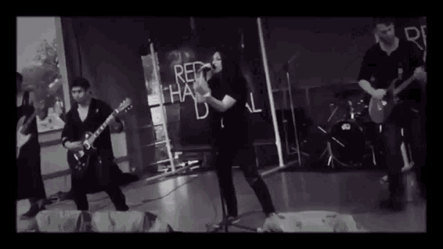 a black and white photo of a band with a sign that says red hand on it