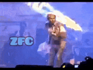 a man stands on a stage in front of a screen that has zfc written on it