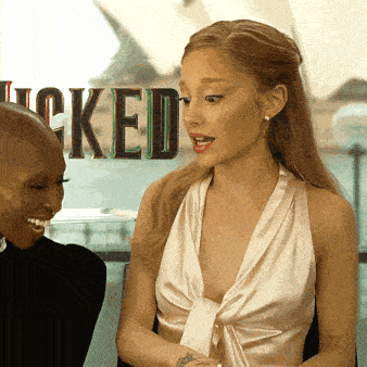 a woman in a white dress is talking to another woman in front of a sign that says locked