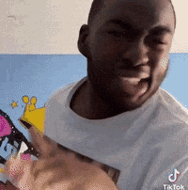 a man wearing a white t-shirt with tiktok written on it is smiling