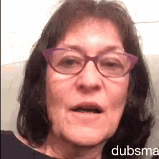 a close up of a woman wearing purple glasses with dubsma written in the corner