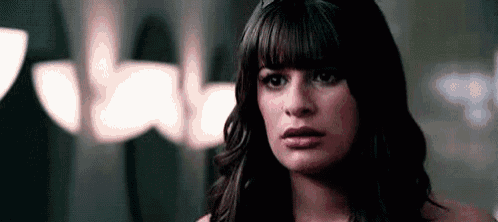 a close up of a woman 's face looking at the camera with a serious look on her face .
