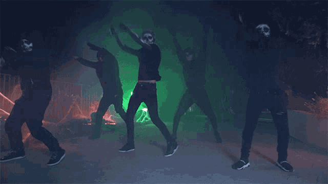 a group of skeletons are dancing in front of a cemetery