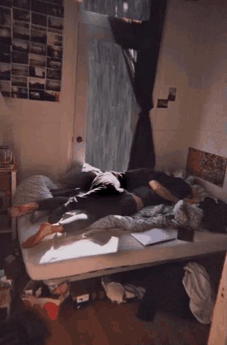 two people are laying on a bed in a room