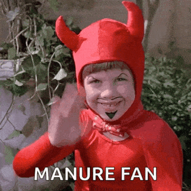 a child dressed in a devil costume is giving the middle finger and says manure fan