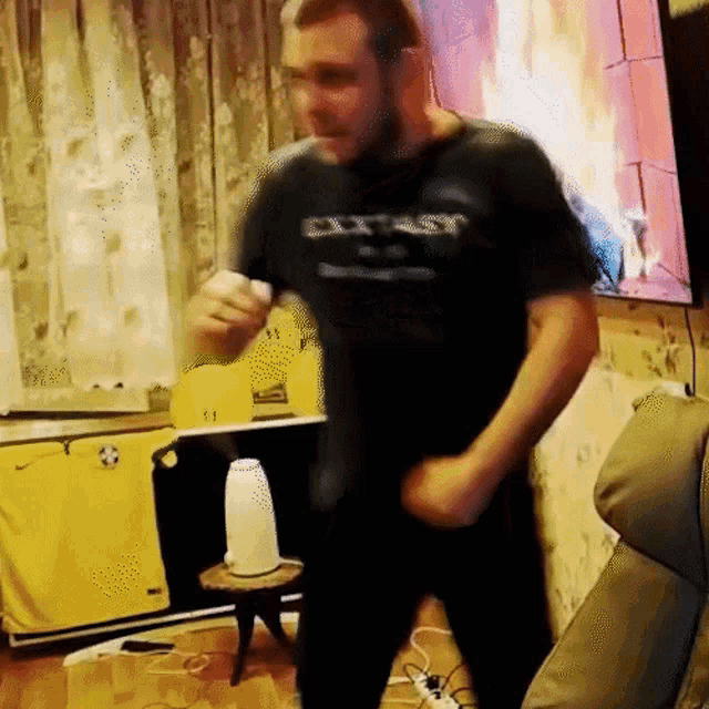 a man wearing a black shirt that says extrasy