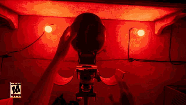 a person is holding a camera in a room with red lights and a warning label that says " not for children under 14 "