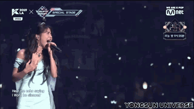 a woman singing into a microphone with the words " yongsun universe " on the bottom