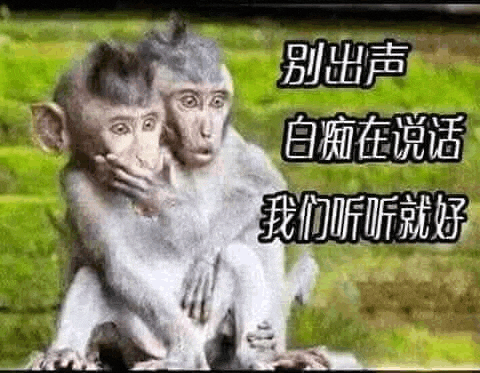 a couple of monkeys sitting next to each other covering their mouths with their hands .
