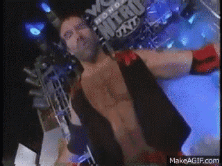 a wrestler is standing in front of a sign that says nitro on it