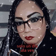 a woman wearing glasses and red lipstick with the words solo un dia ala ves on the bottom