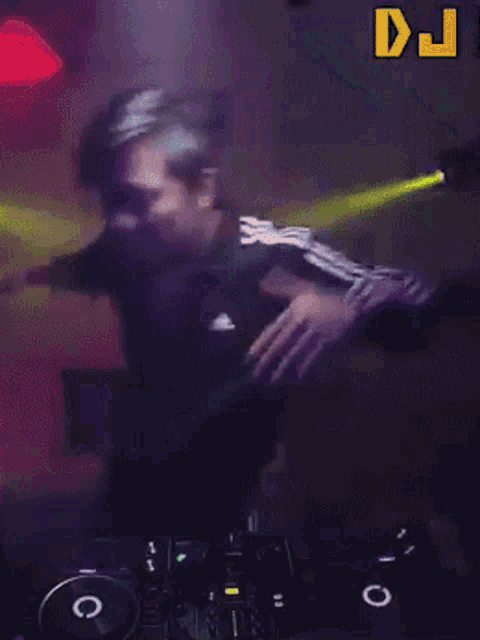 a man is dancing in front of a dj mixer